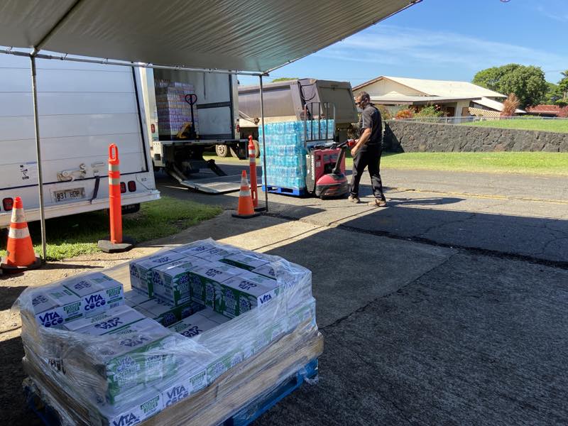 Volunteers unload pallets of donated water